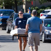 2 GVSU alumni carrying large item together